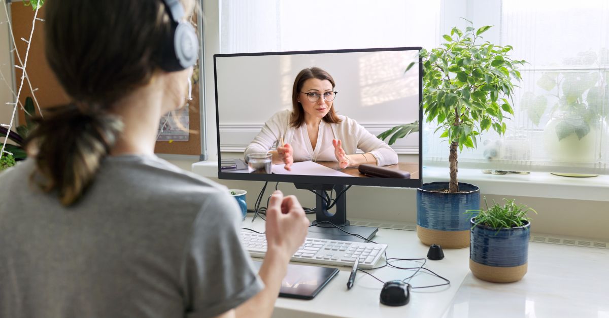 Early childhood educator sitting at a computer and participating in an online webinar