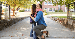 Dad and preschool daughter hugging goodbye on first day of school