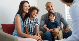 Family of four meeting with preschool teacher during teacher conference