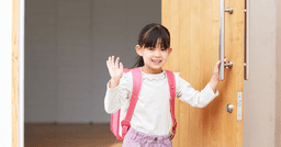 Little girl waving goodbye on first day of preschool