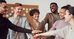 Group of early childhood educators putting their hands together and smiling