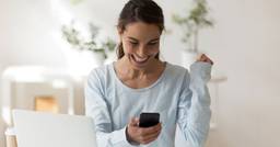 Preschool parent smiling and looking at update of her child on her Lillio App