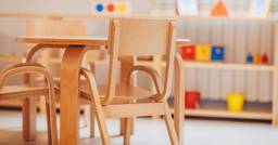 Photo of wooden chair and tables in preschool classroom